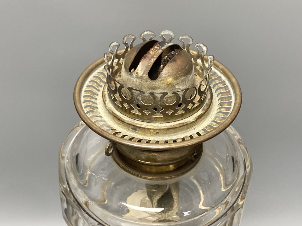 A late 19th century cut glass oil lamp with floral embossed shade, 61cm high including shade